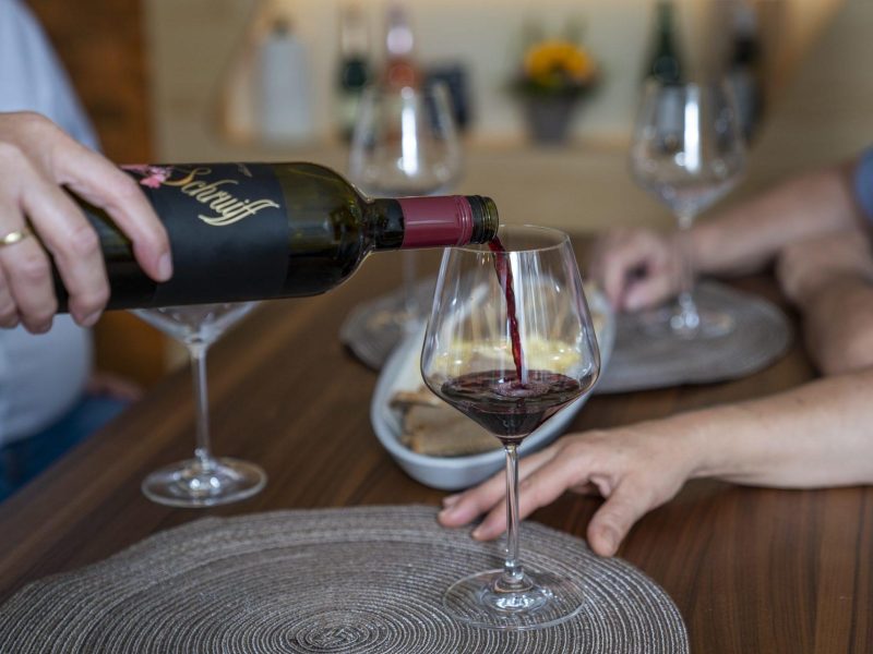 Rotwein in Weinglas einschenken